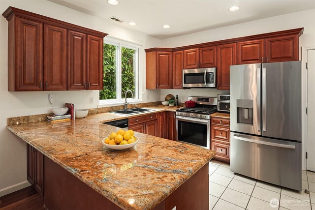 545 SE Lewis St, Issaquah, WA 98027 - kitchen featuring light stone counters, visible vents, a sink, a peninsula, and stainless steel appliances