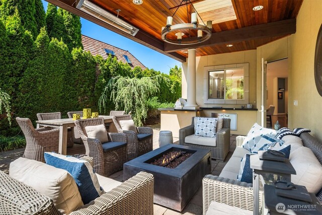 view of patio / terrace featuring an outdoor living space with a fire pit and an outdoor kitchen