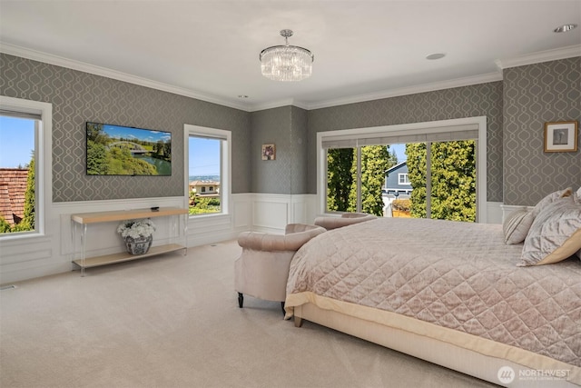 bedroom with wallpapered walls, multiple windows, crown molding, a chandelier, and a wainscoted wall