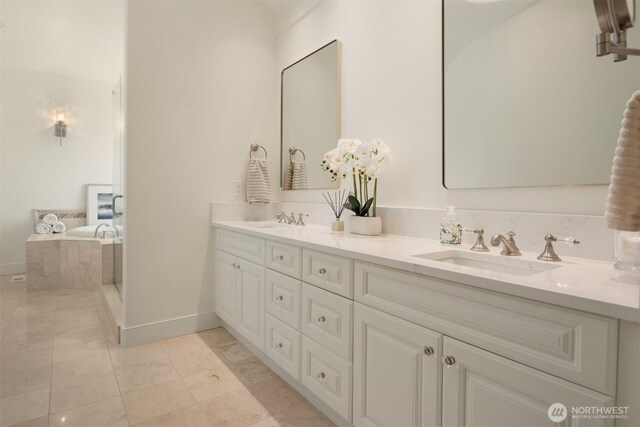 full bathroom featuring double vanity, baseboards, and tiled tub