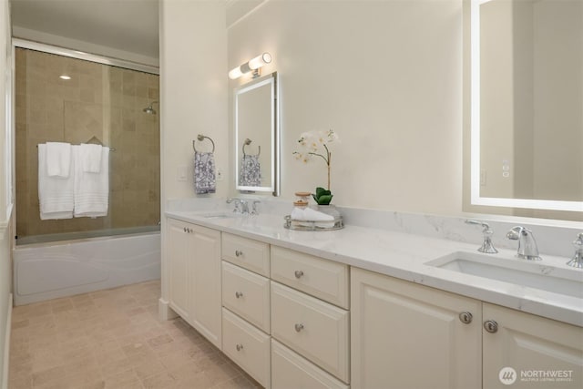 bathroom featuring bath / shower combo with glass door and double vanity