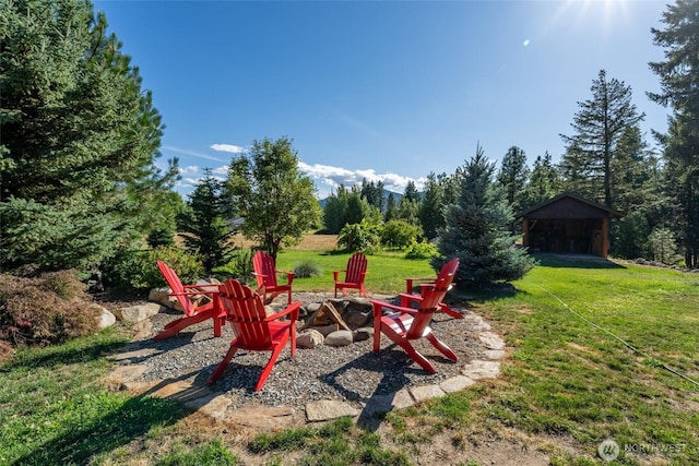 view of yard featuring an outdoor fire pit and an outdoor structure