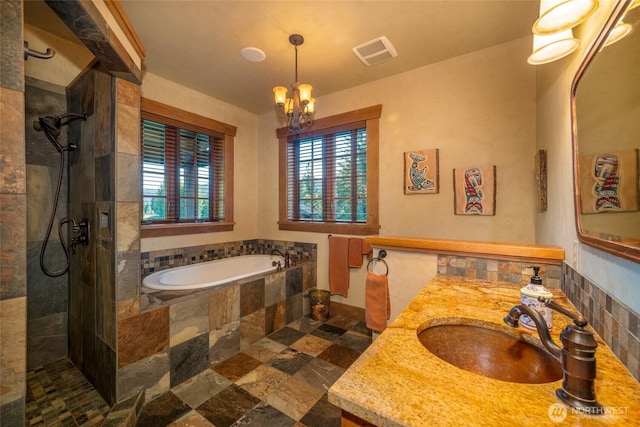 full bathroom with stone tile floors, visible vents, a tile shower, a garden tub, and vanity