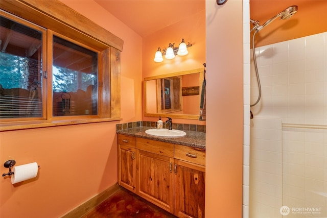 bathroom with walk in shower, baseboards, and vanity