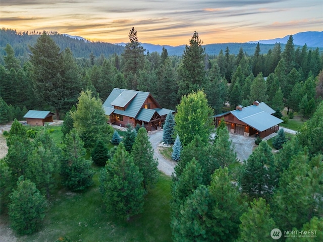 aerial view at dusk with a wooded view and a mountain view