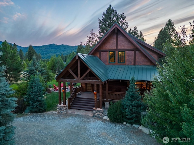view of front facade featuring covered porch, metal roof, a standing seam roof, and a mountain view