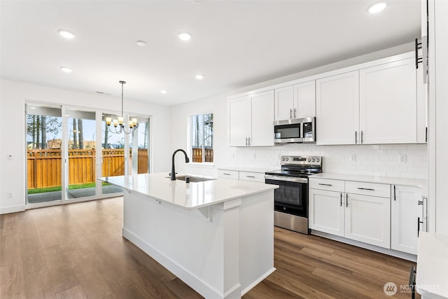 20336 150th St E Unit 588, Bonney Lake, WA 98391 - kitchen featuring stainless steel appliances, a sink, a chandelier, dark wood-style flooring, and tasteful backsplash