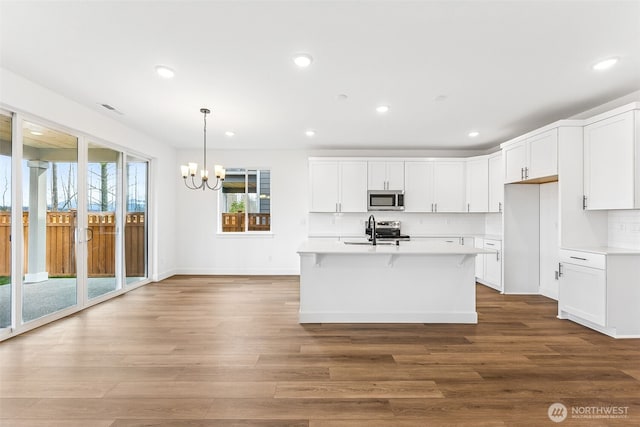 20336 150th St E Unit 588, Bonney Lake, WA 98391 - kitchen featuring stainless steel appliances, a chandelier, light countertops, wood finished floors, and recessed lighting