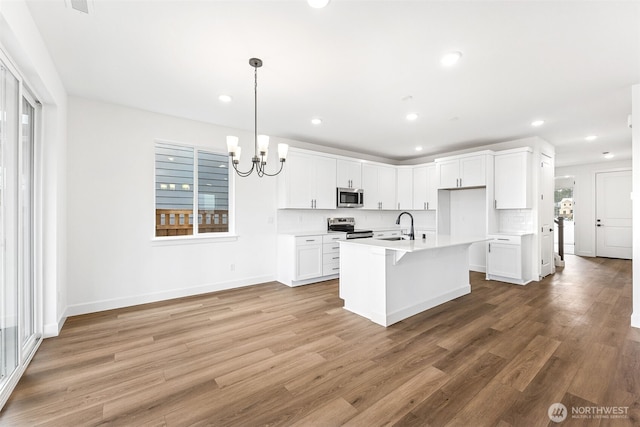 20336 150th St E Unit 588, Bonney Lake, WA 98391 - kitchen with appliances with stainless steel finishes, a sink, light wood-style flooring, a chandelier, and light countertops