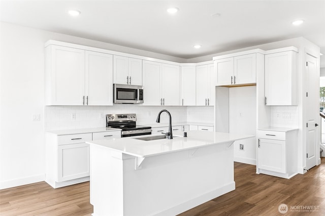 20336 150th St E Unit 588, Bonney Lake, WA 98391 - kitchen with stainless steel appliances, a sink, light wood finished floors, decorative backsplash, and recessed lighting