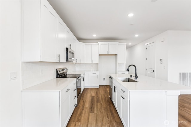 20336 150th St E Unit 588, Bonney Lake, WA 98391 - kitchen with appliances with stainless steel finishes, a sink, wood finished floors, light countertops, and backsplash