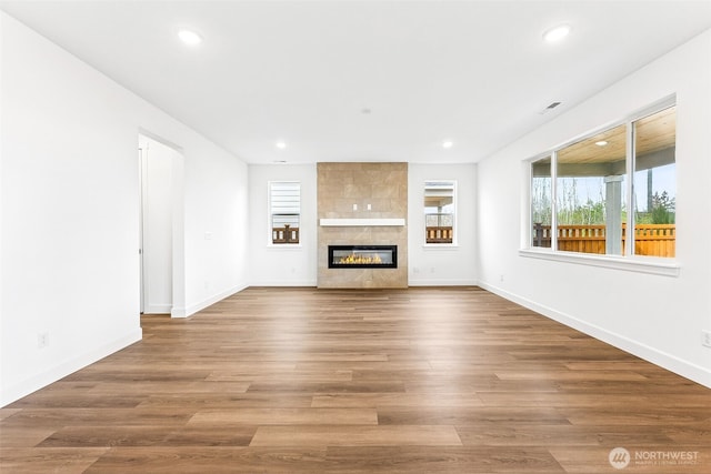 20336 150th St E Unit 588, Bonney Lake, WA 98391 - unfurnished living room featuring recessed lighting, a tiled fireplace, baseboards, and wood finished floors