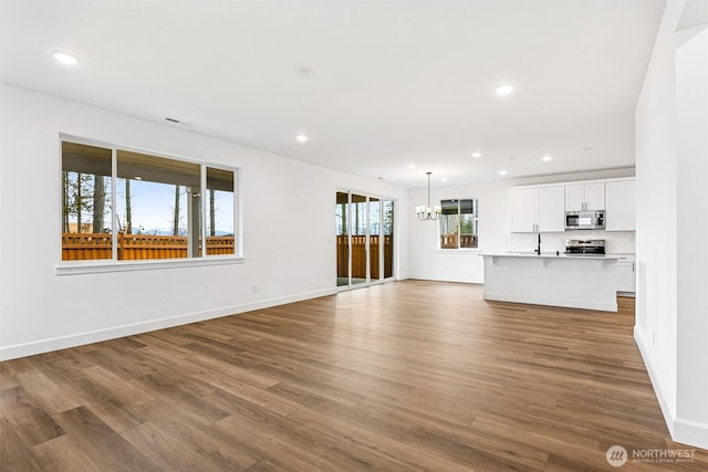 20336 150th St E Unit 588, Bonney Lake, WA 98391 - unfurnished living room featuring a chandelier, dark wood-type flooring, recessed lighting, and baseboards