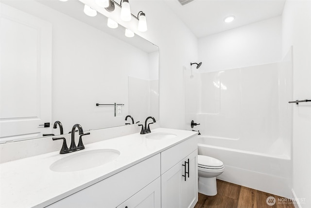 20336 150th St E Unit 588, Bonney Lake, WA 98391 - bathroom with toilet, wood finished floors, double vanity, and shower / bathtub combination