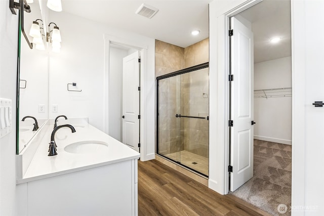 20336 150th St E Unit 588, Bonney Lake, WA 98391 - bathroom featuring a stall shower, double vanity, a spacious closet, wood finished floors, and recessed lighting