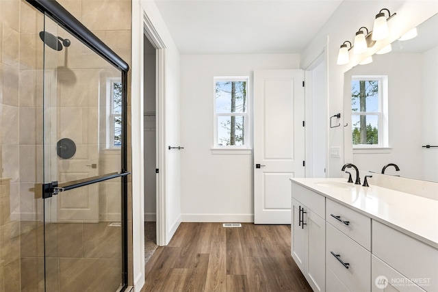 20336 150th St E Unit 588, Bonney Lake, WA 98391 - bathroom featuring wood finished floors, tiled shower, vanity, and baseboards