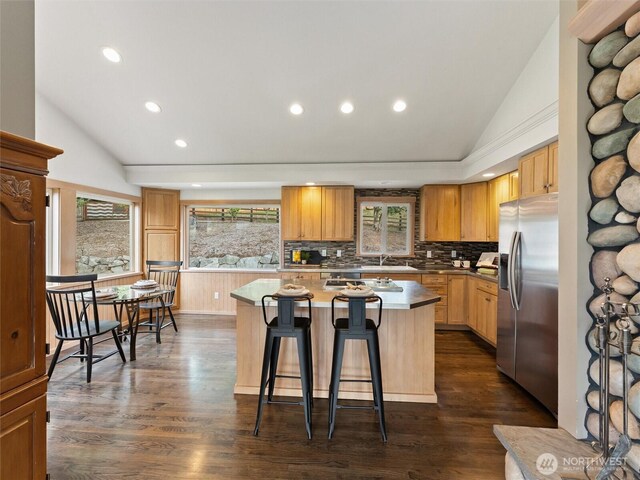 21608 186th Ave E, Orting, WA 98360 - kitchen featuring stainless steel fridge with ice dispenser, vaulted ceiling, recessed lighting, a kitchen island, and a breakfast bar area