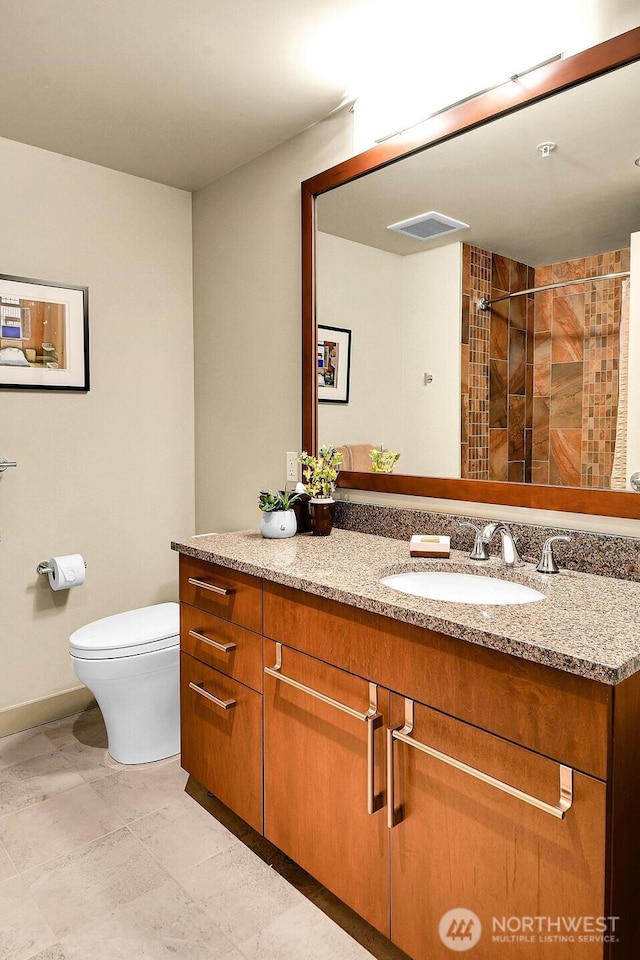 2121 Terry Ave Unit N1203, Seattle, WA 98121 - bathroom featuring toilet, tiled shower, vanity, and baseboards