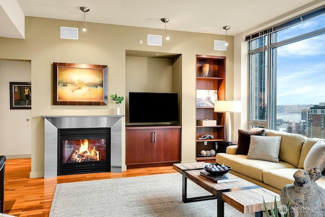 2121 Terry Ave Unit N1203, Seattle, WA 98121 - living room featuring wood finished floors, built in shelves, and a glass covered fireplace