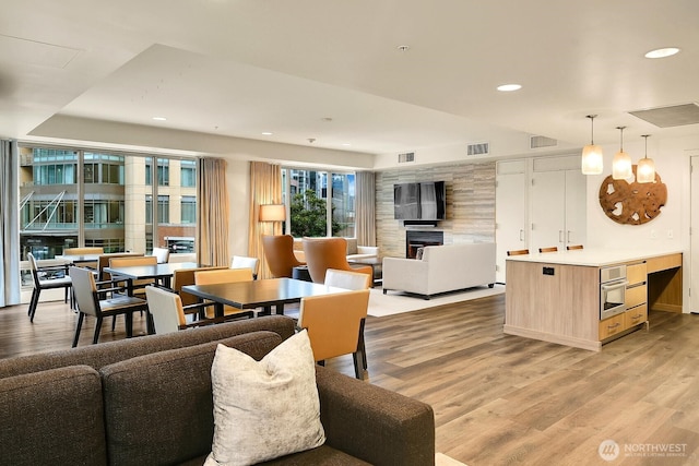 2121 Terry Ave Unit N1203, Seattle, WA 98121 - dining area with light wood-type flooring, recessed lighting, and a large fireplace