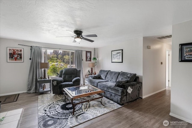 living area with wood finished floors, baseboards, and ceiling fan