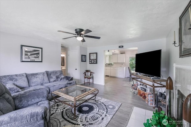 living area featuring a ceiling fan and light wood finished floors