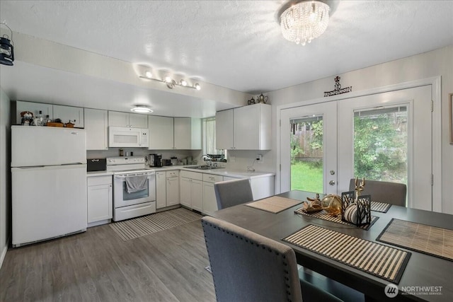 kitchen featuring french doors, white appliances, a sink, wood finished floors, and light countertops