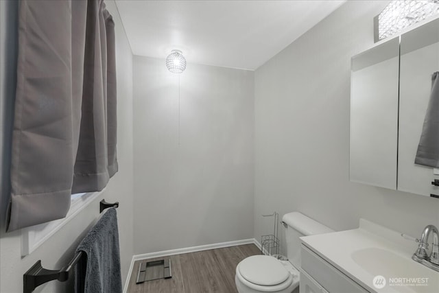 bathroom featuring toilet, wood finished floors, visible vents, baseboards, and vanity
