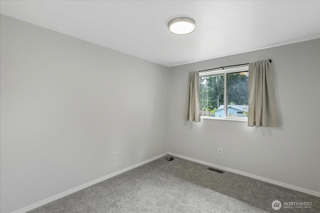 unfurnished room with visible vents, baseboards, and carpet floors