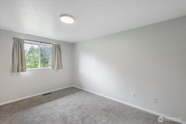unfurnished room featuring carpet floors, baseboards, and visible vents