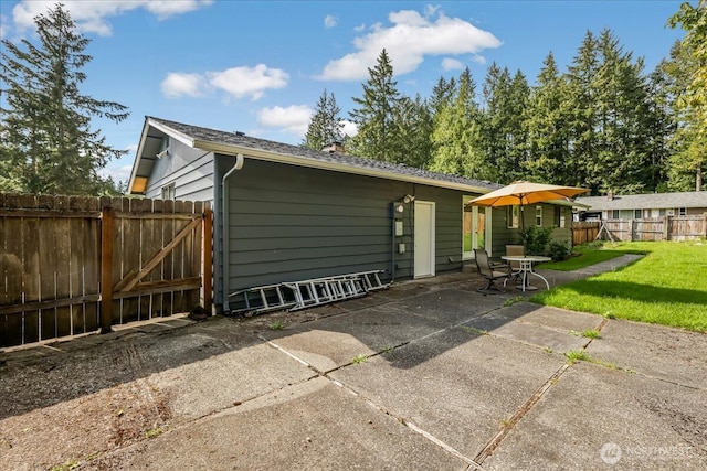 exterior space with a lawn, a patio, and fence