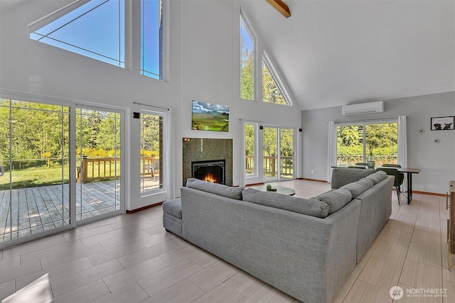 4716 167th Ave NW, Lakebay, WA 98349 - living room featuring high vaulted ceiling, an AC wall unit, a warm lit fireplace, light tile patterned floors, and baseboards