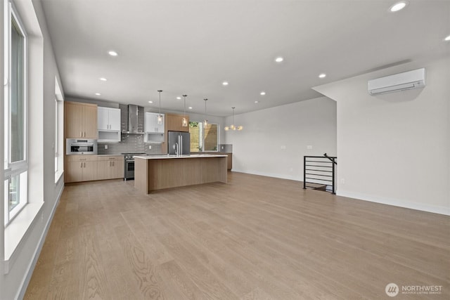 kitchen with wall chimney range hood, a wall mounted AC, and recessed lighting