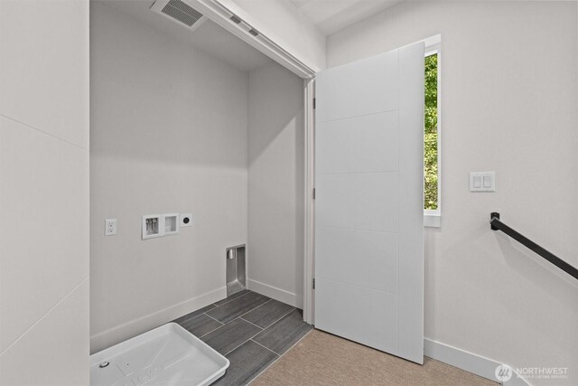 clothes washing area featuring laundry area, visible vents, baseboards, and washer hookup