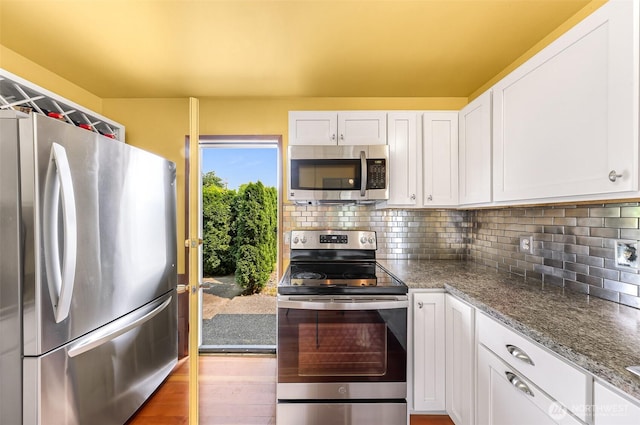 832 Elm Ave, Blaine, WA 98230 - kitchen with stainless steel appliances, white cabinets, decorative backsplash, wood finished floors, and stone countertops