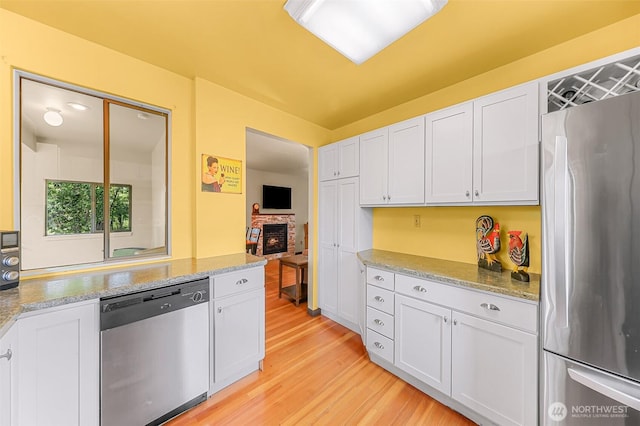 832 Elm Ave, Blaine, WA 98230 - kitchen featuring stainless steel appliances, light wood-style floors, white cabinets, and light stone countertops