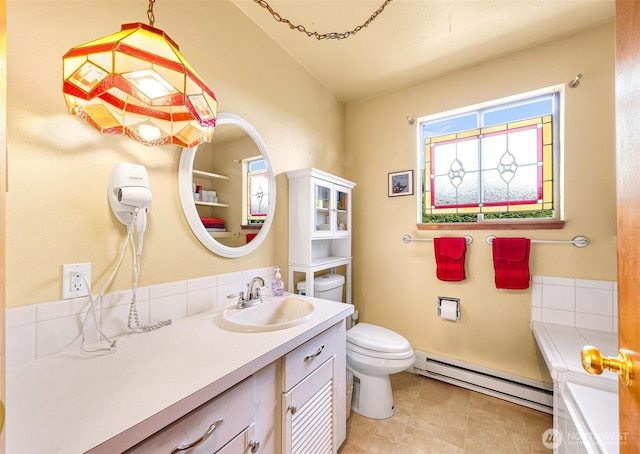 832 Elm Ave, Blaine, WA 98230 - bathroom with a baseboard heating unit, toilet, a bathtub, vanity, and vaulted ceiling