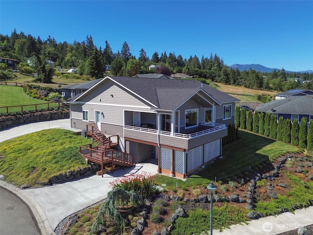 view of front facade featuring concrete driveway, stairs, and a front lawn