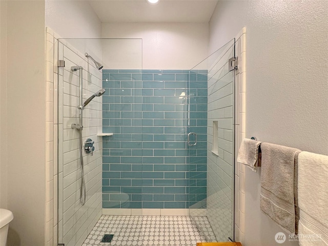 full bathroom with toilet, a shower stall, and tile patterned floors