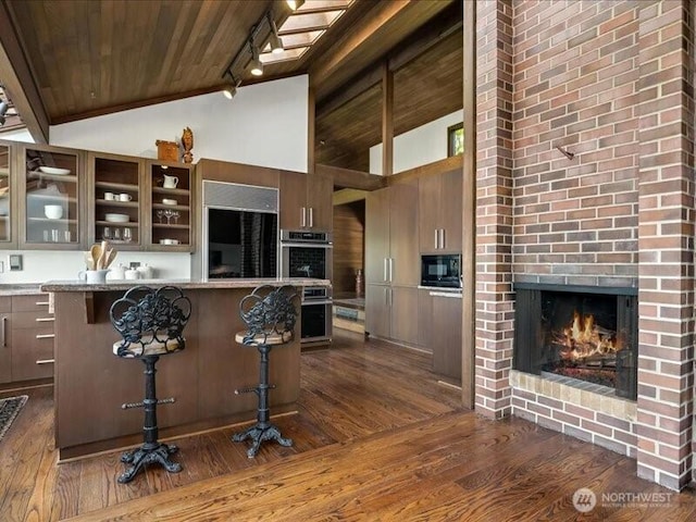 4400 E Mercer Way, Mercer Island, WA 98040 - kitchen featuring wooden ceiling, dark wood finished floors, a kitchen bar, black microwave, and stainless steel double oven