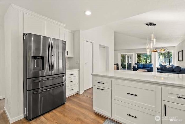 7236 Twin Cedar Ln SE, Tumwater, WA 98501 - kitchen featuring stainless steel refrigerator with ice dispenser, light wood-style flooring, light countertops, white cabinetry, and open floor plan