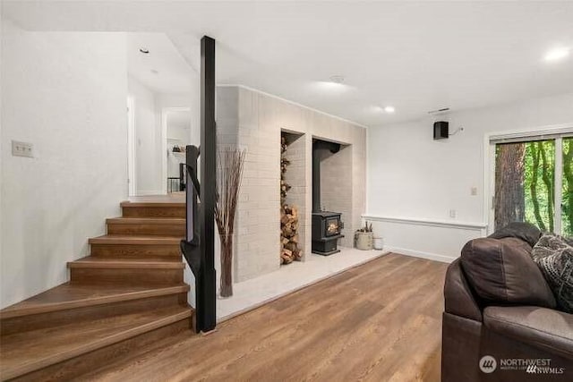 7236 Twin Cedar Ln SE, Tumwater, WA 98501 - living area with a wood stove, wood finished floors, stairs, baseboards, and recessed lighting