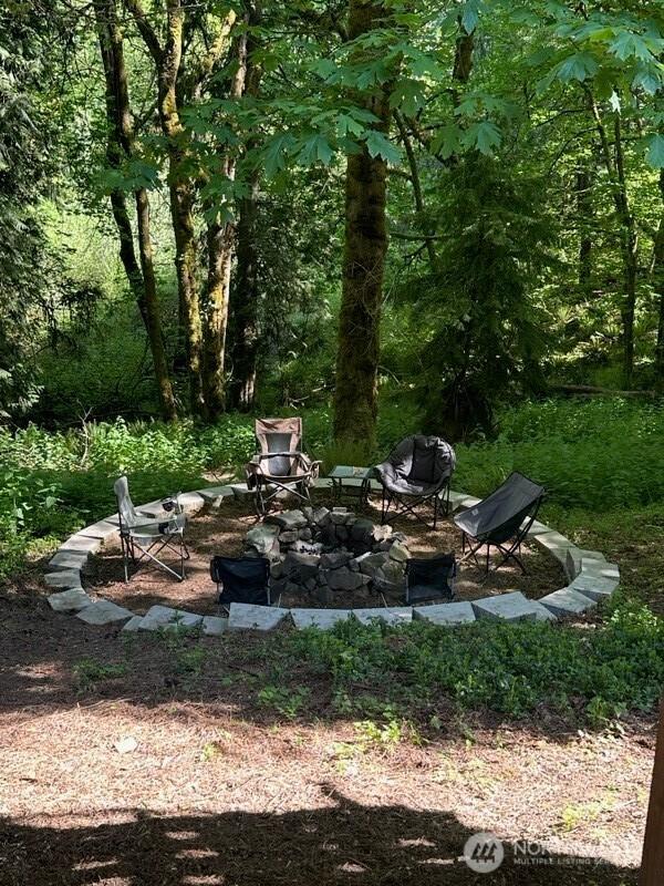 7236 Twin Cedar Ln SE, Tumwater, WA 98501 - view of yard featuring a fire pit and a view of trees