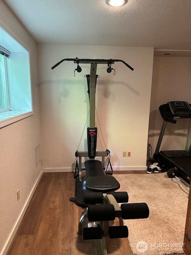 7236 Twin Cedar Ln SE, Tumwater, WA 98501 - workout area featuring dark wood-style flooring, a textured ceiling, and baseboards