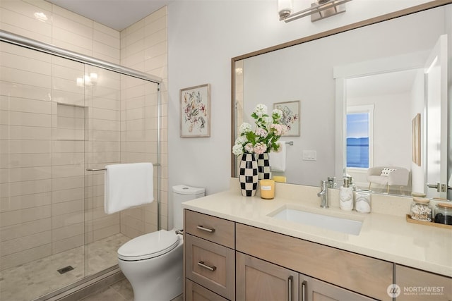 bathroom with vanity, toilet, a shower stall, and tile patterned flooring