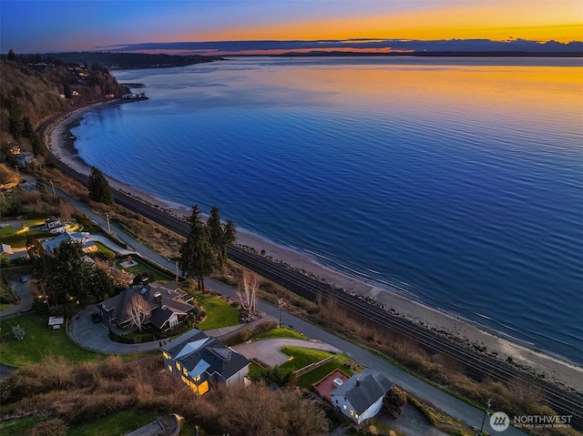 birds eye view of property featuring a water view and a beach view