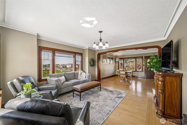 28009 SE 456th St, Enumclaw, WA 98022 - living room with a chandelier, a textured ceiling, light wood-style flooring, crown molding, and baseboards