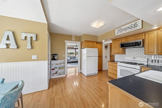 28009 SE 456th St, Enumclaw, WA 98022 - kitchen with white appliances, dark countertops, light wood finished floors, a wainscoted wall, and tasteful backsplash