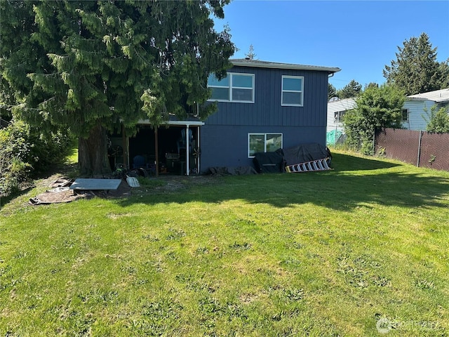 back of property featuring a yard and fence