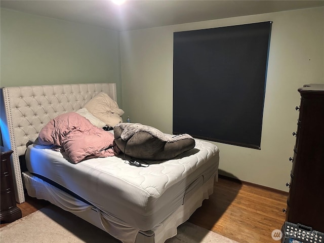 bedroom with wood finished floors and baseboards